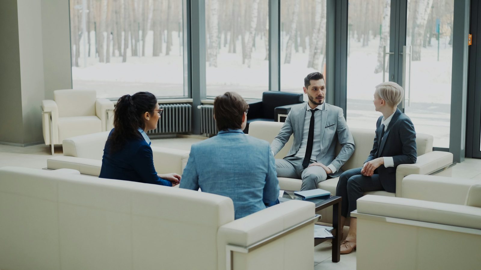 Consultores conversando com clientes em uma sala de reunião clara